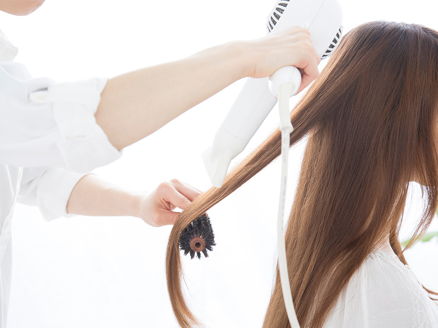 サロンで女性の髪をドライする様子